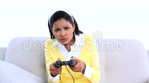集中精力在沙发上玩电子游戏的女人视频的预览图