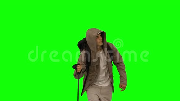 穿着外套在绿色屏幕上跋涉的漂亮男人视频的预览图