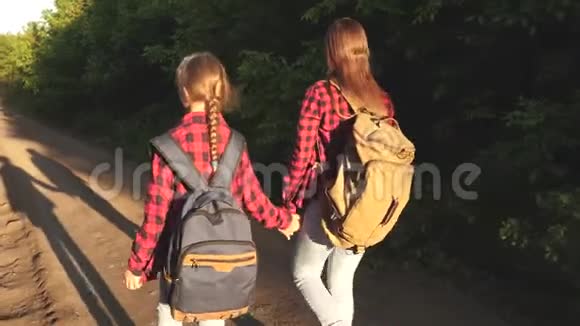 徒步旅行者女孩带背包的女孩在阳光下的乡村道路上体育旅游和旅游的概念儿童视频的预览图