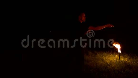 低调年轻的男性长发旋转燃烧火炬户外黑色夜间视频慢动作现代法克尔视频的预览图