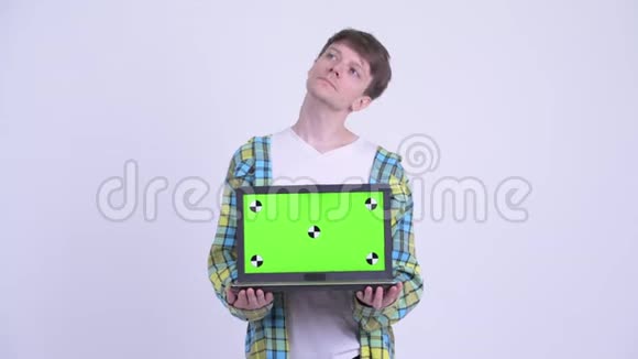 快乐的年轻帅哥一边思考一边展示笔记本电脑视频的预览图