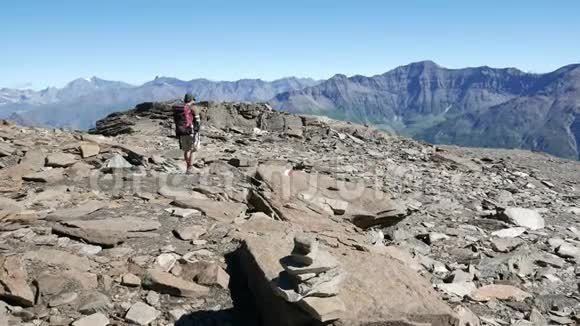 女人在高海拔的岩石山景观中跋涉意大利法国阿尔卑斯山的夏季冒险视频的预览图