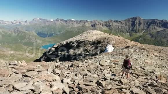 女人在高海拔的岩石山景观中跋涉意大利法国阿尔卑斯山的夏季冒险视频的预览图