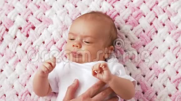 可爱的女婴躺在针织长毛绒毯上视频的预览图