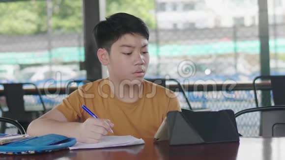 孩子坐在家里的桌子上做作业视频的预览图