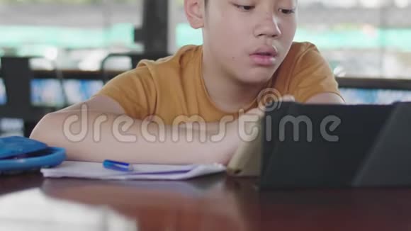 孩子坐在家里的桌子上做作业视频的预览图