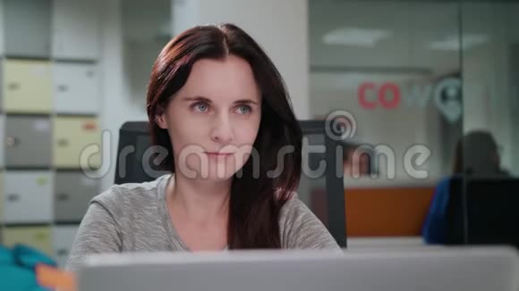 一位女士坐在办公室的笔记本电脑前视频的预览图