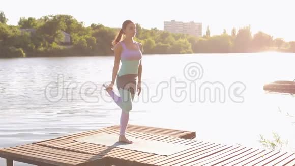 年轻女子在木桥上做瑜伽视频的预览图