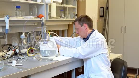 年轻的科学家在实验室里用液体进行化学实验视频的预览图
