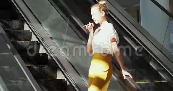 一个年轻的女商人在一座现代化的大楼里的自动扶梯上视频的预览图