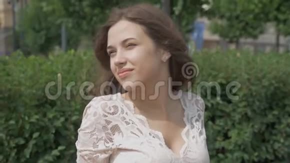 美丽的年轻女子的肖像带着迷人的微笑在阳光明媚的夏天视频的预览图