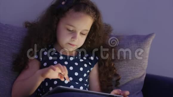 可爱的小女孩花了闲暇时间玩手机游戏并打破明亮的屏幕与她的手概念视频的预览图