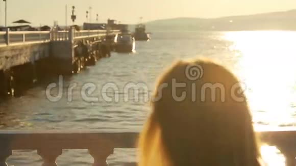 穿着长裙子的女孩沿着海滩散步堤岸视频的预览图
