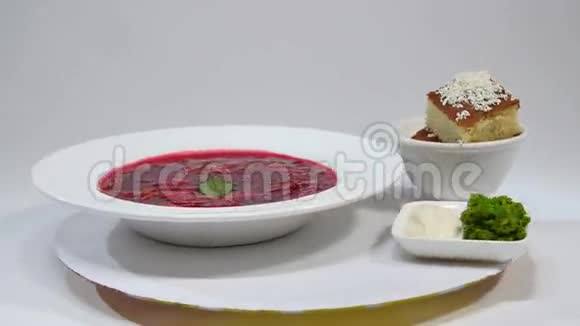 盘子里有肉的红罗施一种美味的红罗宋汤白色盘子上有酸奶油和草药传统乌克兰视频的预览图