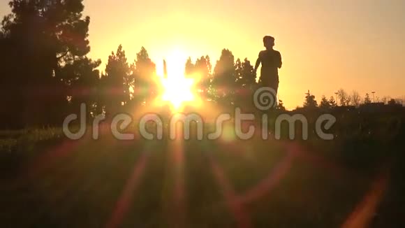日落时奔跑的男孩剪影视频的预览图