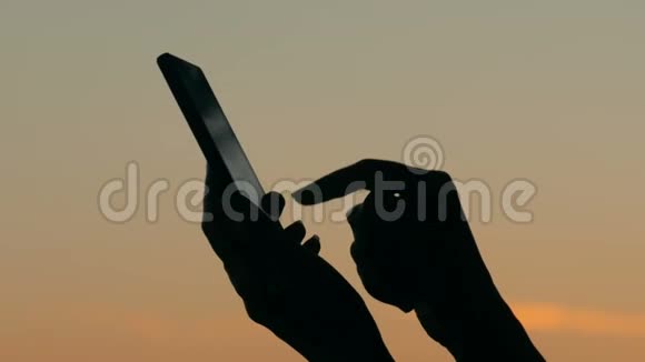 日落后使用智能手机的女人视频的预览图
