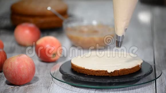 不可辨认的女性糕点厨师在厨房的开胃层蛋糕上挤压奶油视频的预览图