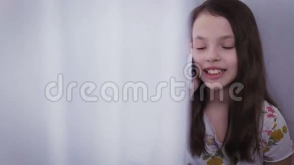 漂亮快乐的小女孩在智能手机上情绪化地交谈视频的预览图