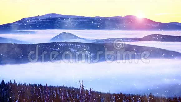圣诞节的早晨下雪而粉红色的橙色日出在雾蒙蒙的冬山之上雾蒙蒙的山谷上方的山峰视频的预览图