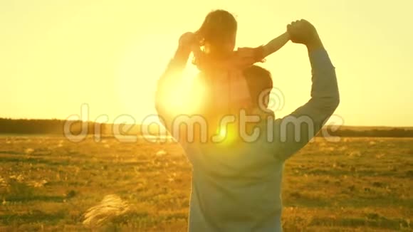 爸爸和他的女儿在阳光下跳舞父亲带着婴儿在夕阳下的肩膀上旅行A视频的预览图