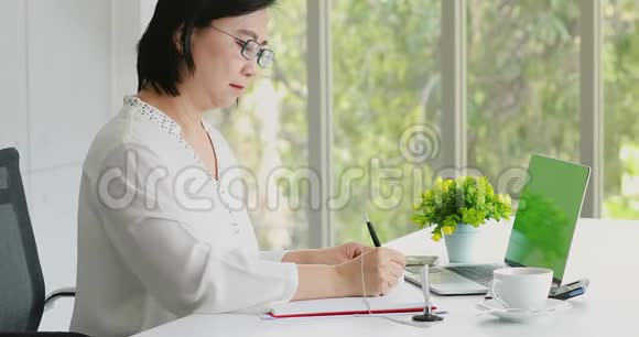 亚洲女商人在办公室里用笔记本电脑视频的预览图