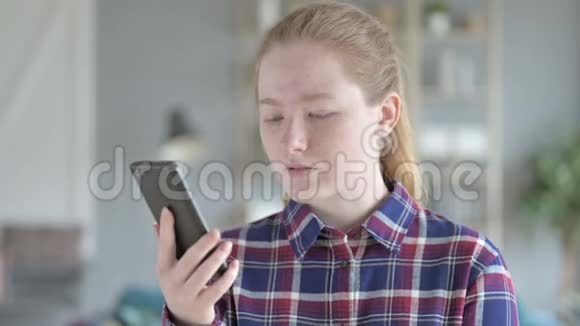 年轻女子用智能手机滚动视频的预览图