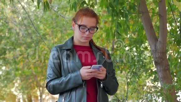 迷人的微笑的年轻女子带着一副快乐的眼镜长着一头红色的长发心情愉快情绪积极视频的预览图
