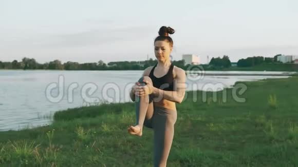 布鲁内特女士在公园练习瑜伽做瑜伽的女孩在草地上移动视频的预览图