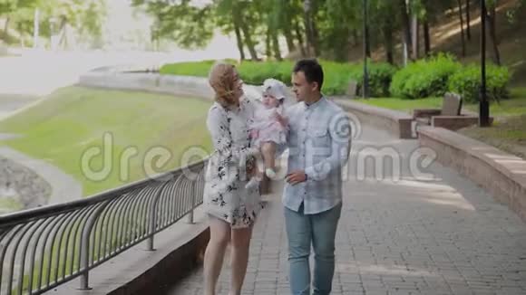 幸福的家庭和一个年幼的孩子在公园里散步视频的预览图