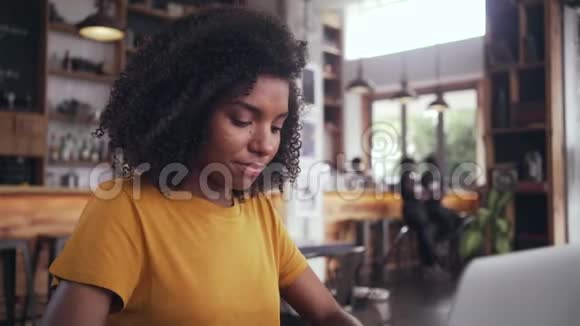 一个女人在室内咖啡馆里用笔记本电脑的画像视频的预览图