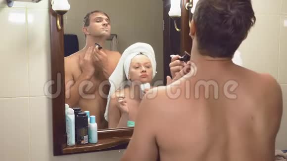 美丽的夫妻男人和女人一起在镜子前的浴室里洗4K慢动作丈夫视频的预览图