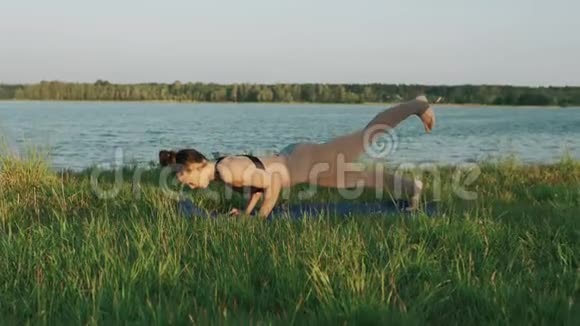 布鲁内特女士在公园练习瑜伽做瑜伽的女孩在草地上移动视频的预览图