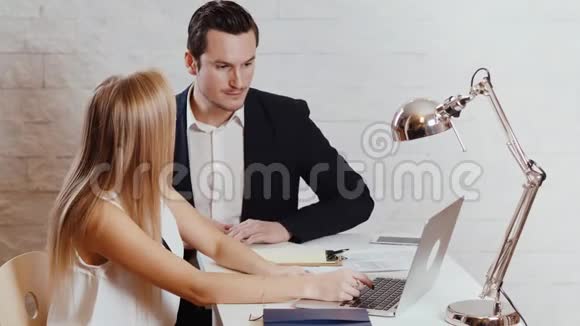 男人和女人正在办公室里看电脑视频的预览图