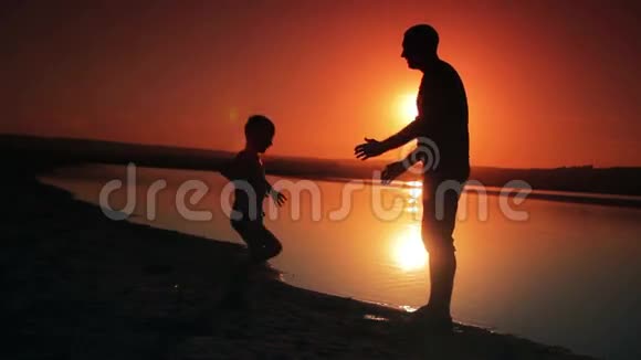 日落时分父亲和儿子在海滩上玩耍视频的预览图