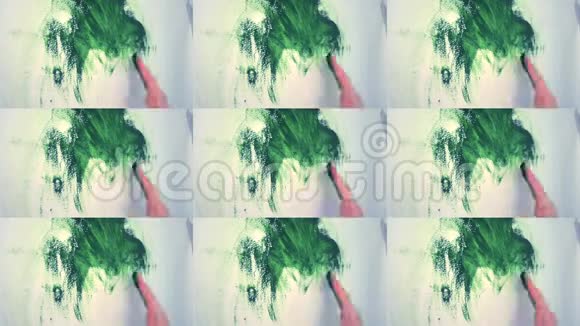 女孩用绿色油漆把手放在白色的墙上视频的预览图