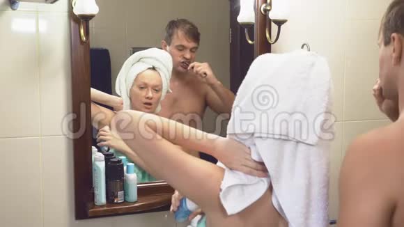 美丽的夫妻男人和女人一起在镜子前的浴室里洗4K慢动作丈夫视频的预览图