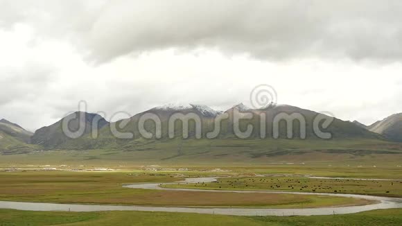云团滚滚越过西藏山河流流经草原视频的预览图