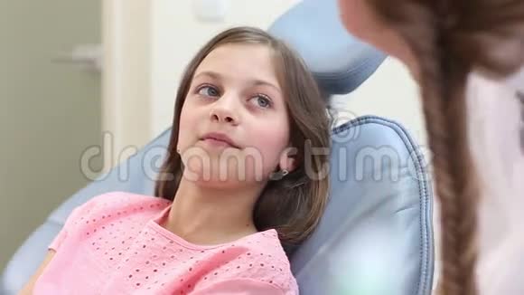 把坐在牙科椅上和牙医说话的小女孩关起来视频的预览图