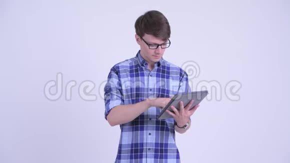 快乐的年轻英俊的嬉皮士用数码平板电脑思考视频的预览图