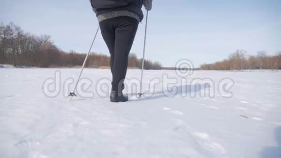 一位老年妇女在冬季森林里用木棍做北欧人的散步健康的生活方式观念成熟成熟视频的预览图