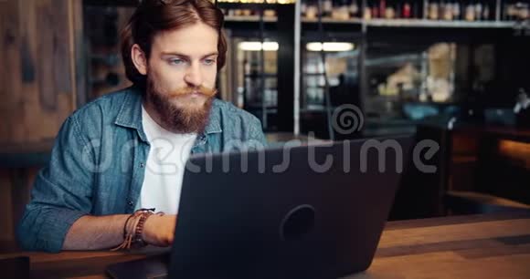 时尚男士在咖啡厅浏览笔记本电脑视频的预览图