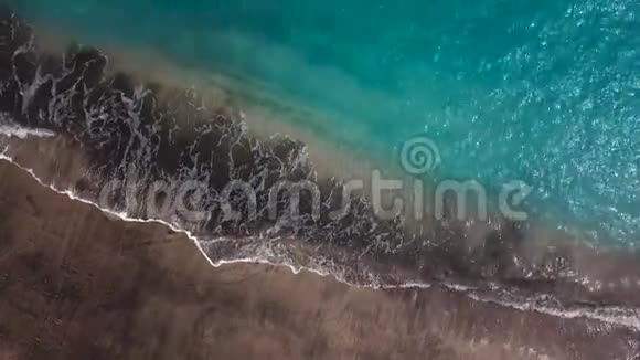 俯瞰一片荒芜的黑色火山海滩特内里费岛海岸空中无人机拍摄的海浪到达视频的预览图