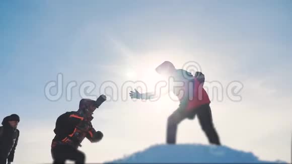 团队合作团队旅游徒步旅行者伸出援手成功赢得冬天到达山顶游客视频的预览图