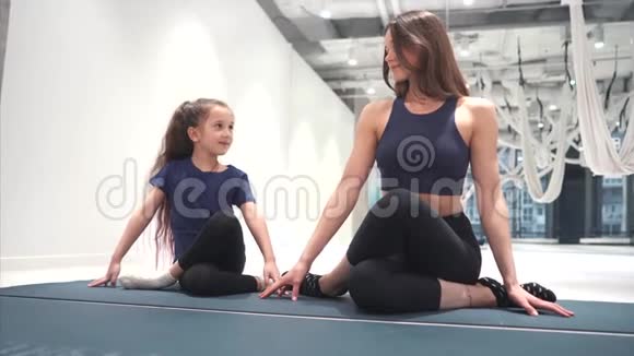 年轻的成年妈妈和小女儿一起做有氧运动视频的预览图
