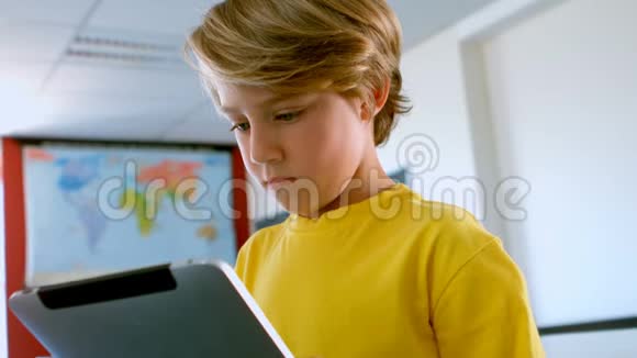 在学校教室里使用数字平板电脑的可爱白人男孩视频的预览图