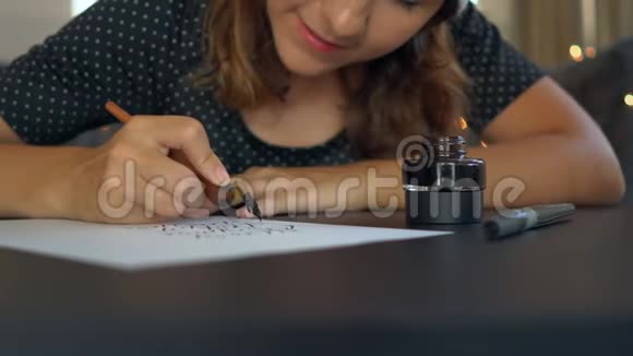 一位年轻女子用刻字手法在纸上书写书法的特写镜头视频的预览图