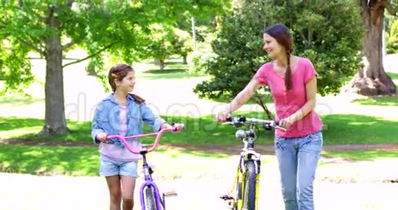 可爱的母女在公园骑自行车视频的预览图