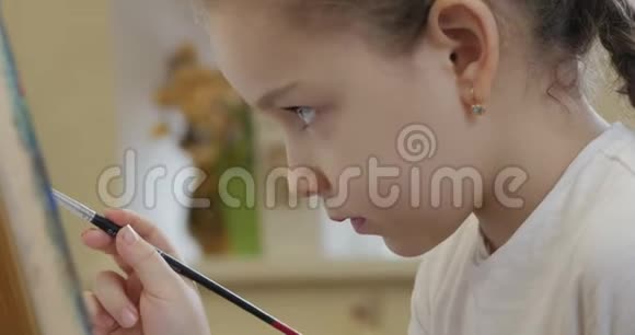 年轻的艺术家的手小女人艺术家用画笔画一幅画布坐在桌子上画画布程序视频的预览图