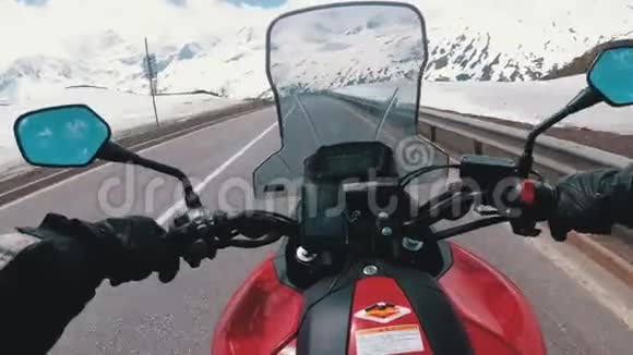 在瑞士阿尔卑斯山附近的美丽风景雪山公路上骑摩托车视频的预览图