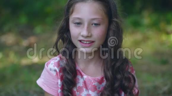 美丽的小女孩在花园里微笑视频的预览图